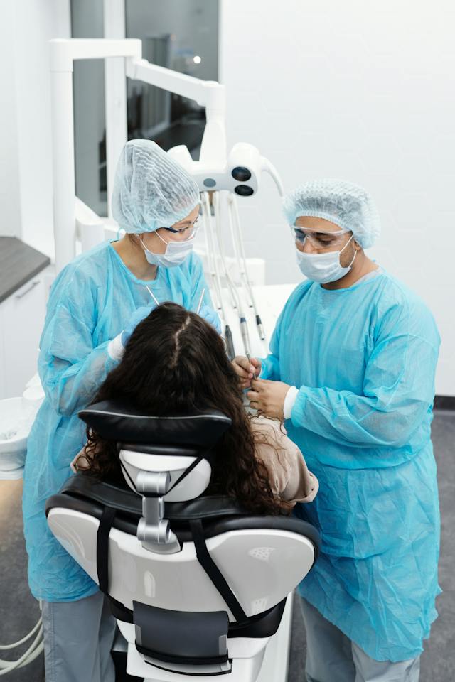 par-de-dentistas-atendiendo-una-paciente